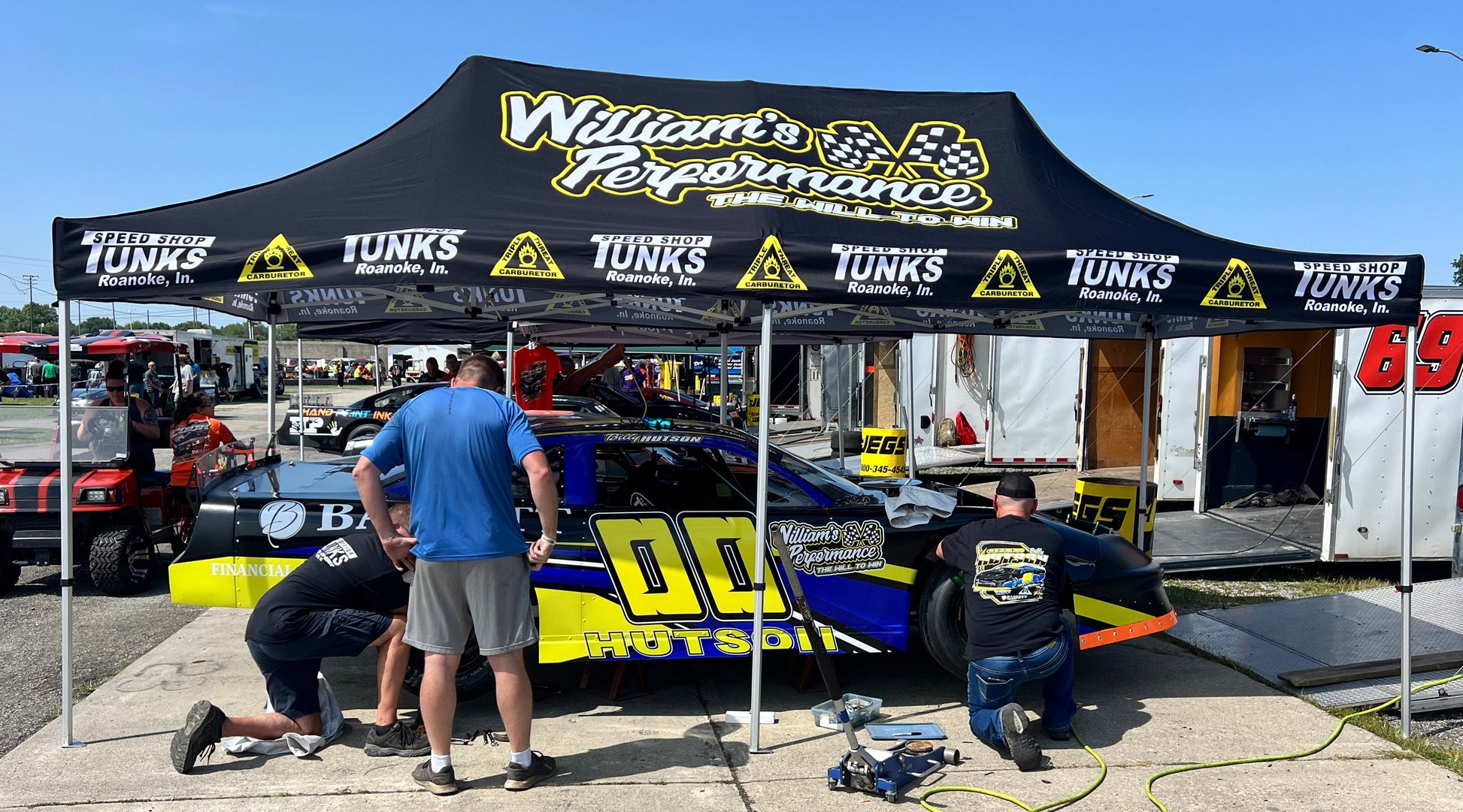 Billy Hutson using a custom P1 covers canopy at the track to keep the car cool.