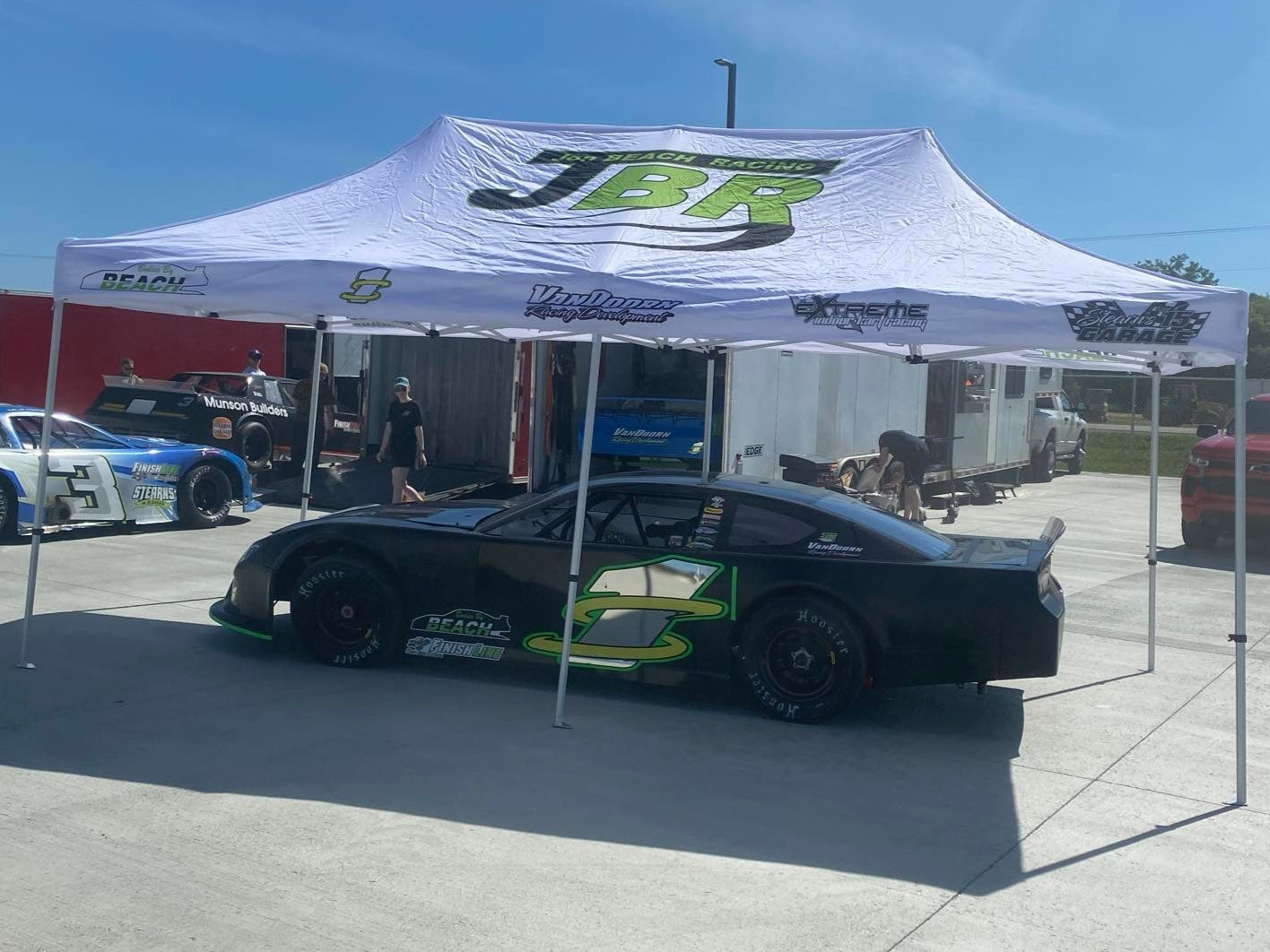 Custom racing tent with team branding, durable frame, and weather-resistant canopy for motorsport events and pit setups.